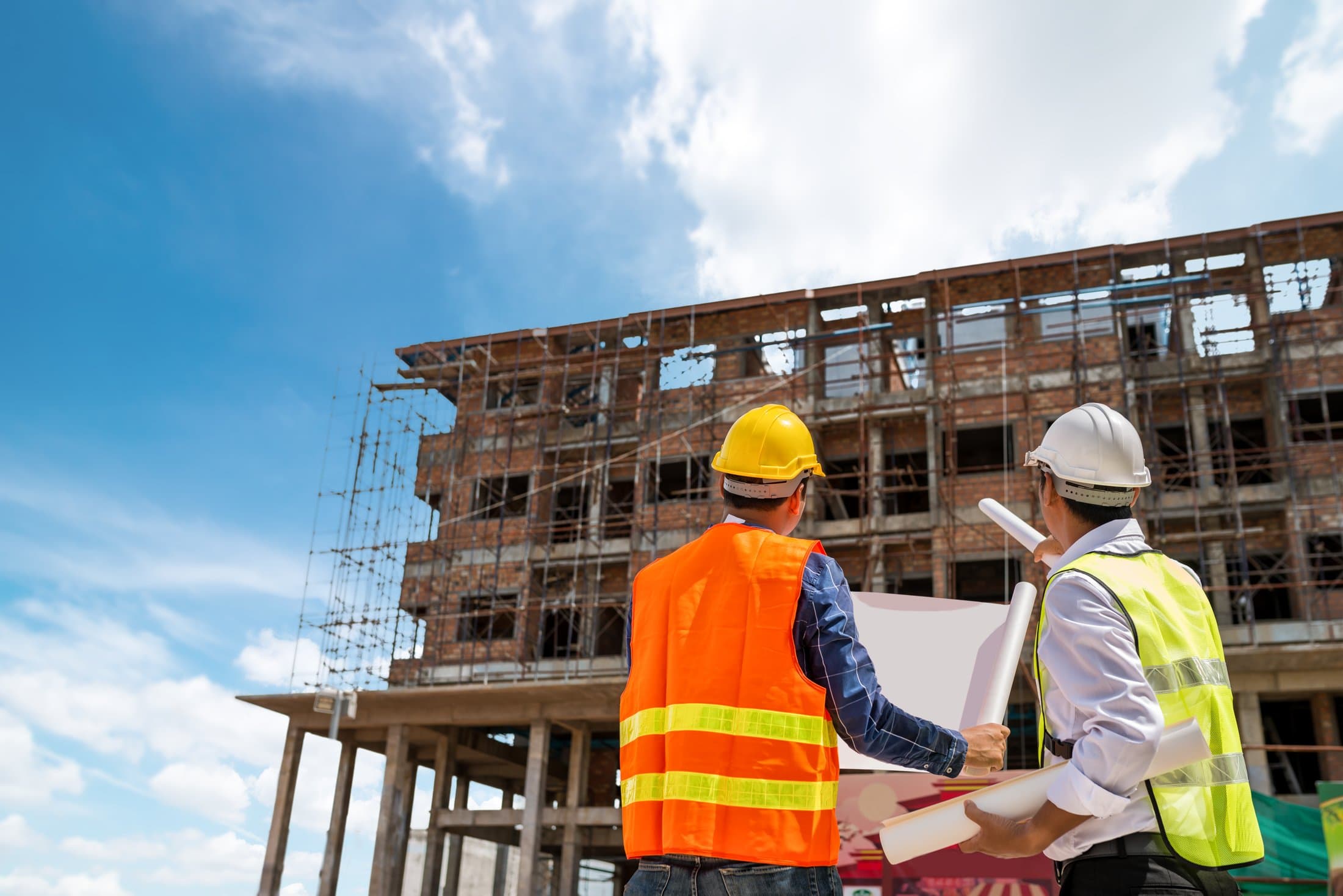 Ingeniero y obrero revisando planos en una obra en construcción